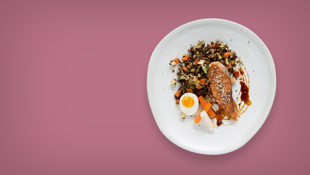 Düz bir arka plan rengiyle beyaz seramik üzerinde bir yemek tabağının flatlay fotoğrafı.