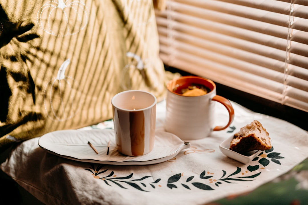Candles, tea, and cookies on a windowsill in sunlight, autumn atmosphere